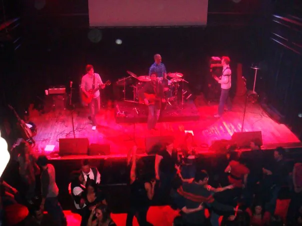 The band playing a stage lit in red.