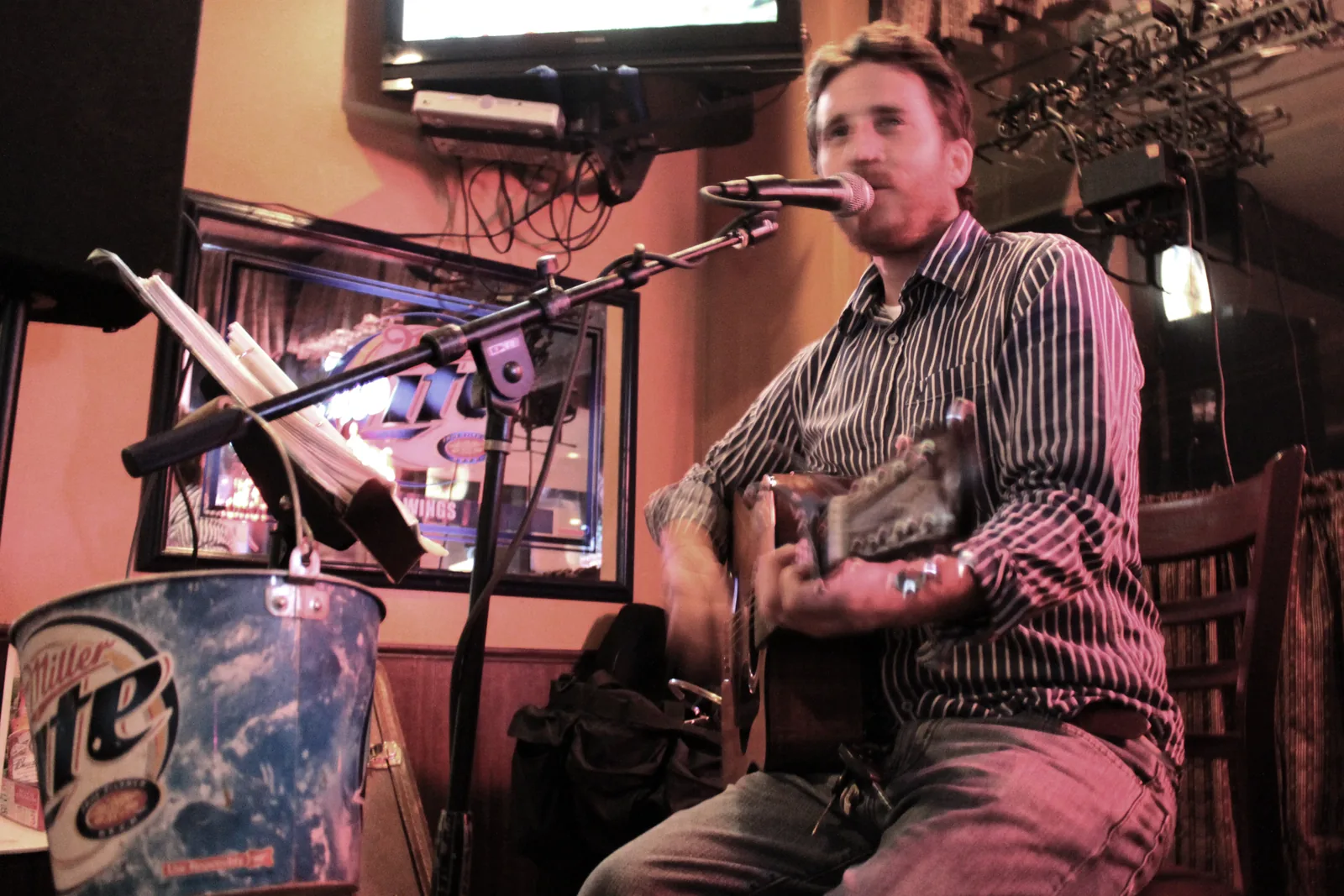 Chris Cahill playing guitar during a bar set.
