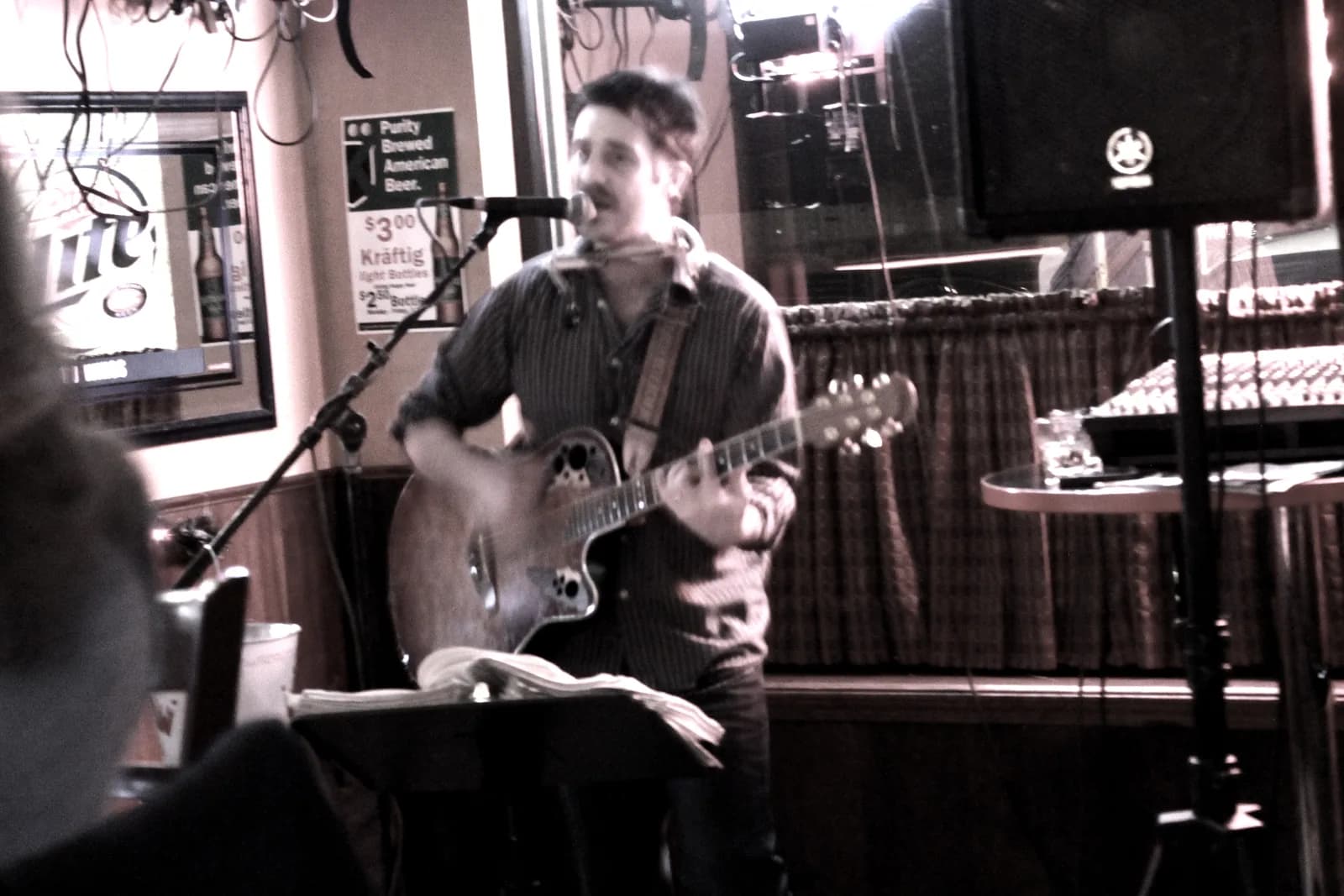 Chris Cahill performing to the audience at a bar show.